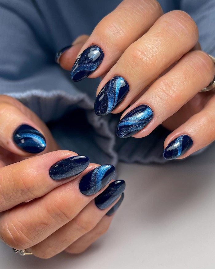 Blue, ocean-inspired cat eye nails with wave effect