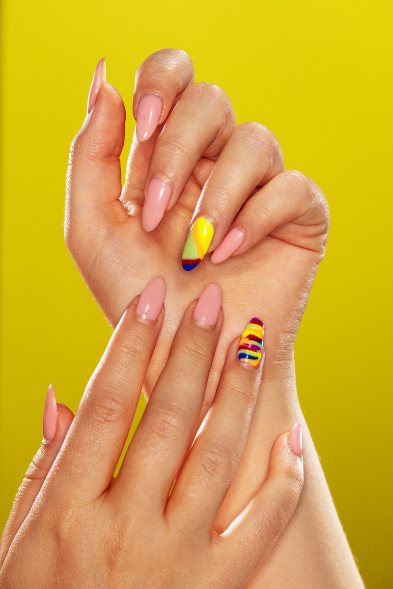 Close-up of hands with vibrant Carnival-themed nail art from the Tips & Test HIV awareness pop-up in Peckham