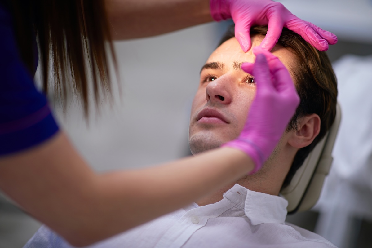 Man receiving Botox treatment, highlighting the inclusion of injectables in new UK aesthetic licensing regulations.
