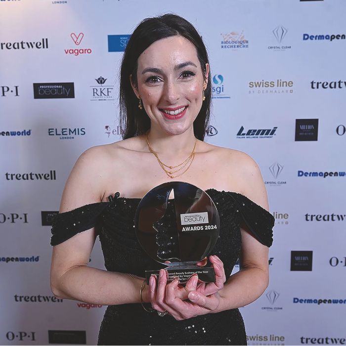 Image of Hayley Snishko, a brunette woman in her 30s, holding a trophy