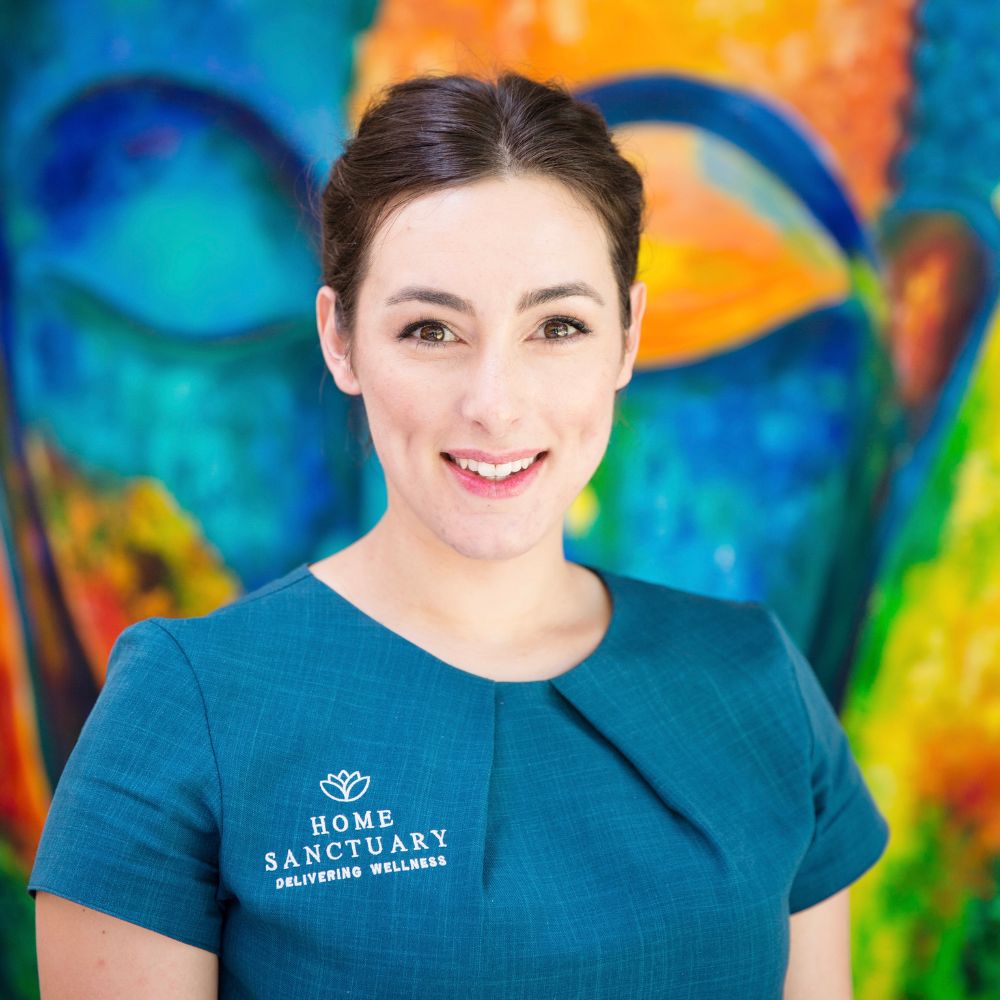 Headshot of Hayley Snishko, smiling and facing the camera, against a colourful background