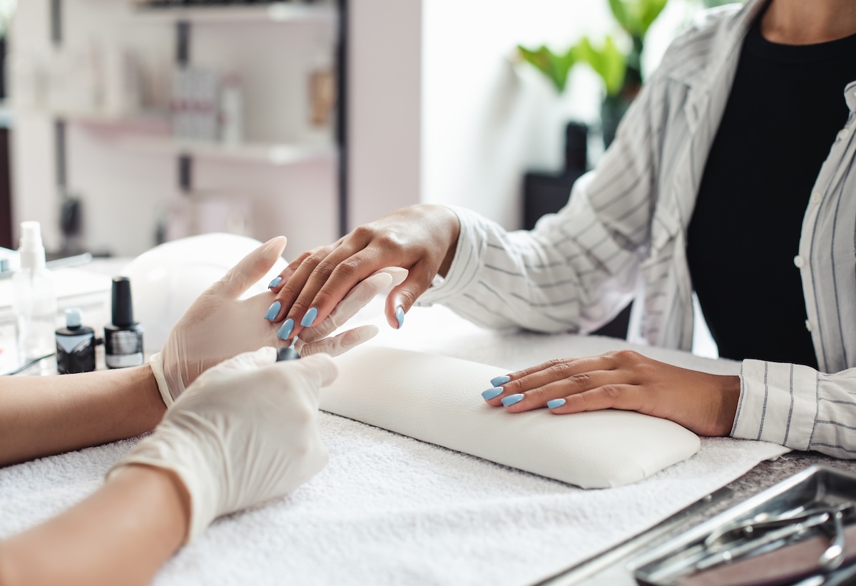 A beauty therapist carefully paints a client’s nails in a modern salon, creating a calm and welcoming environment