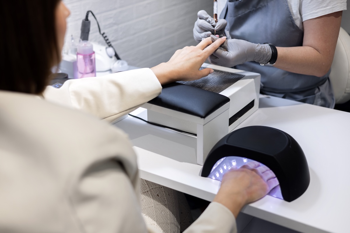 Client curing gel polish under a professional UV LED nail lamp for safe and complete curing