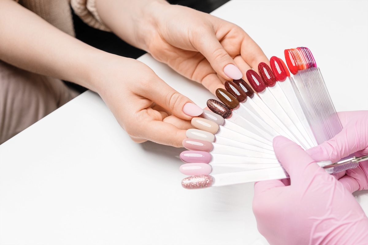 Client selecting a gel polish colour from nail swatch samples at a professional salon