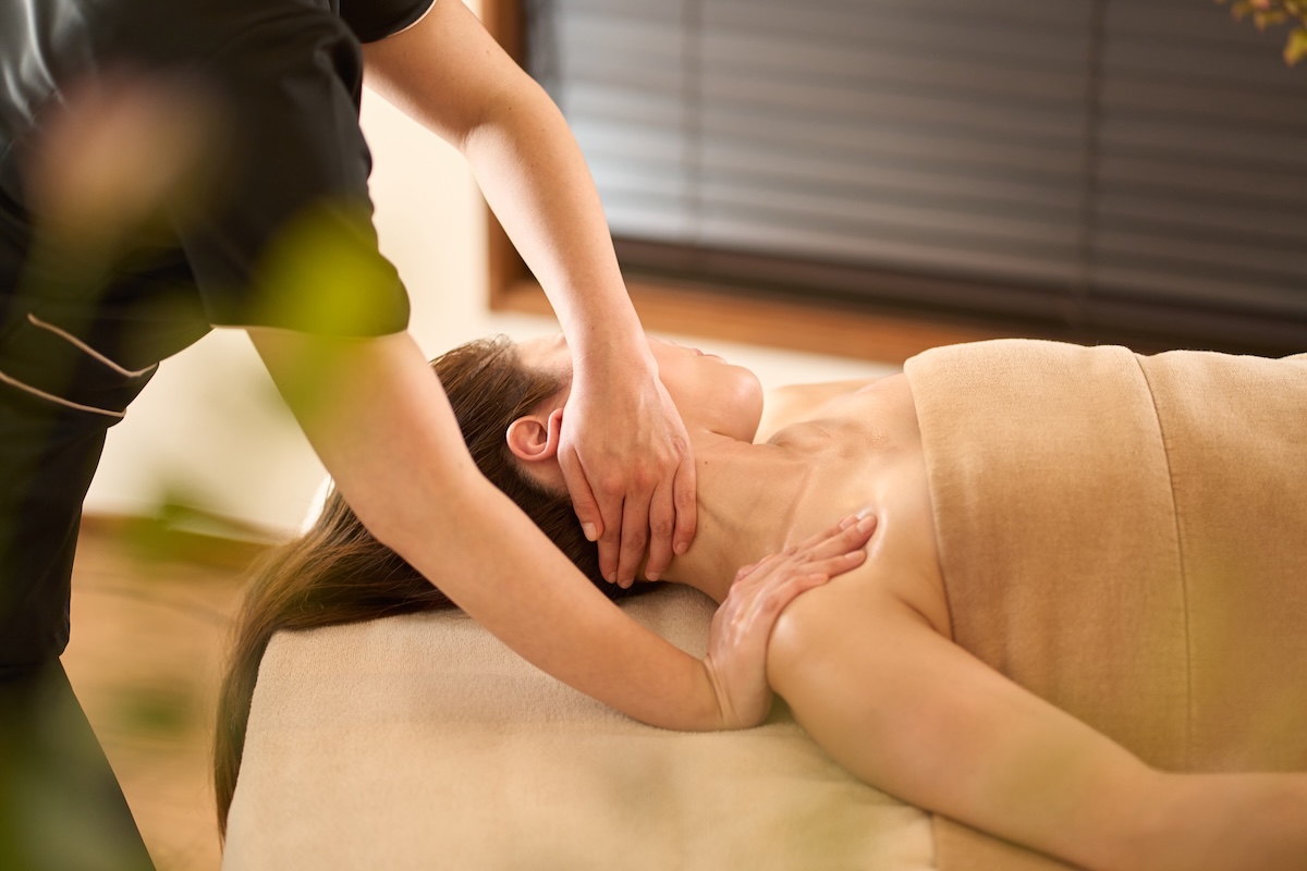 Beauty therapist giving a shoulder massage during a trade test to showcase technique and client care