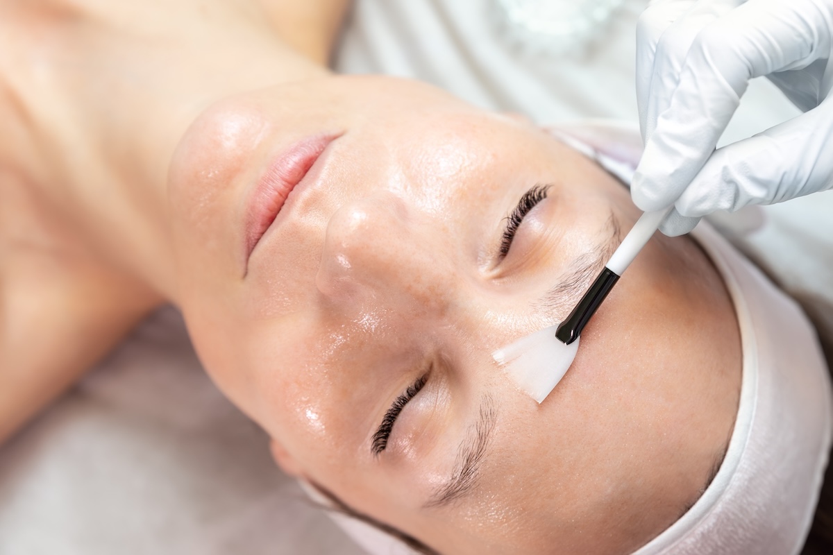 Client receiving a professional skincare facial mask treatment in a salon, reflecting skincare trends