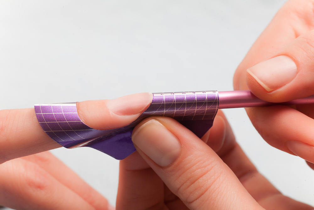 Nail tech applying forms for acrylic nails