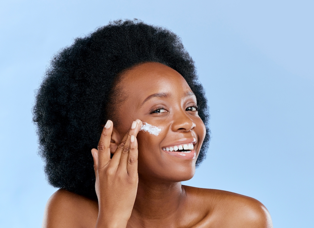 Woman applying moisturiser to her face