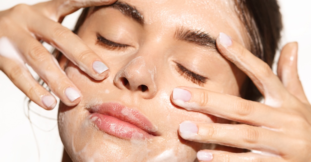 A woman cleansing her face to support a healthy skin barrier and balanced microbiome