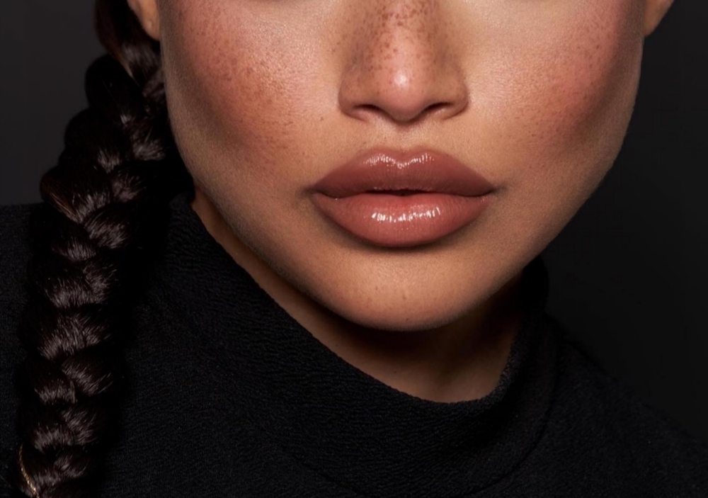 Close up of glossy brown lips and brown-toned blush