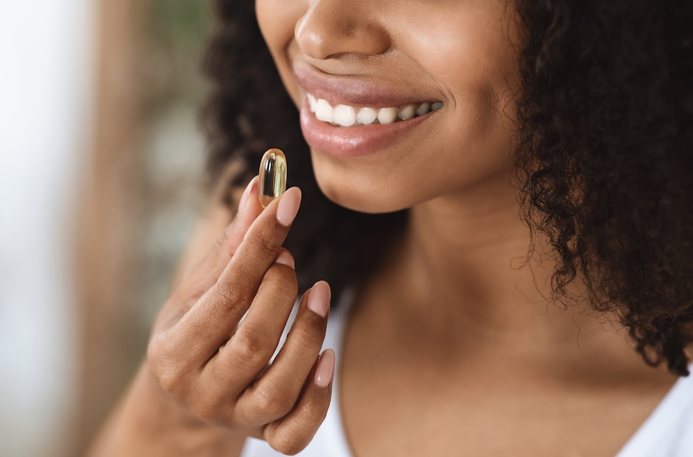 Person taking a beauty supplement, reflecting the rise of inside-out wellness and holistic beauty trends among UK consumers in 2025.