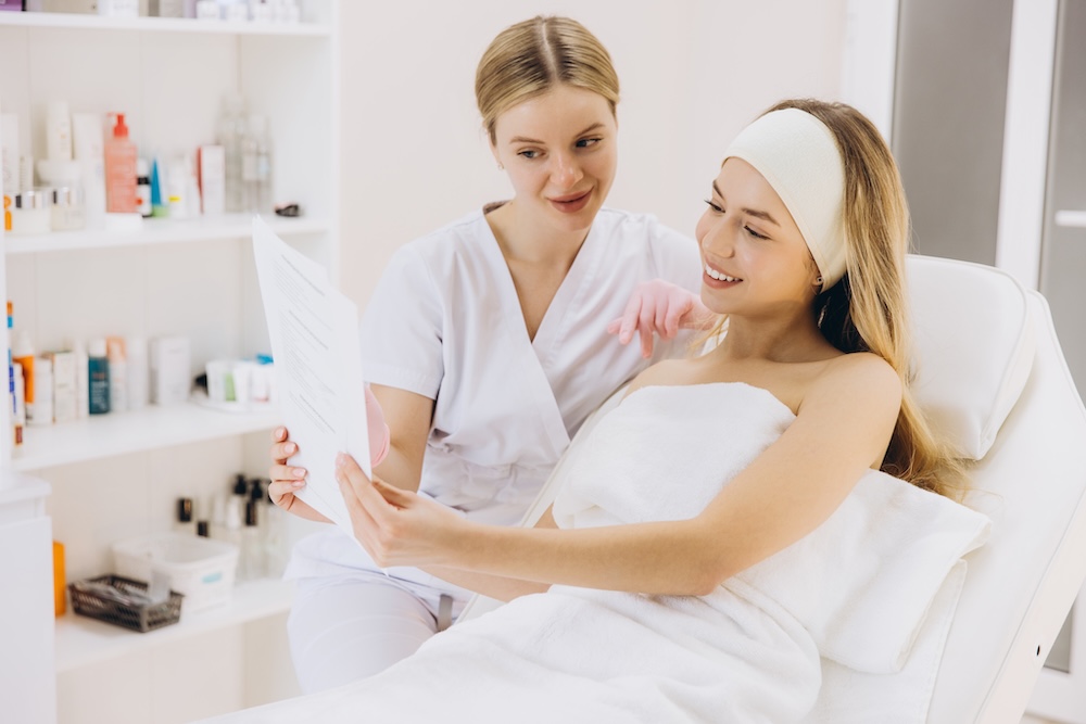 A beauty therapist discussing a personalised home care plan with a client after their treatment