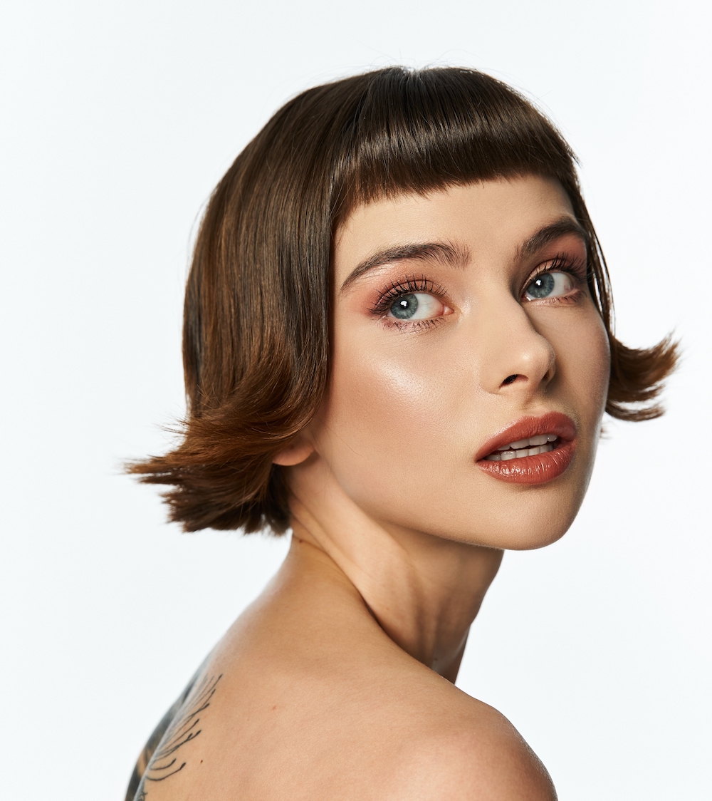 Woman with short flicky bob hairstyle, with minimal eye makeup and glowing skin