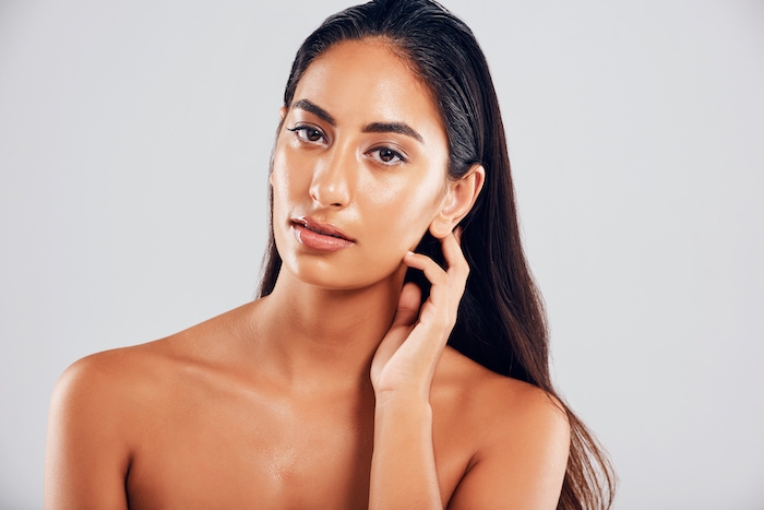 Woman wearing simple winged black eyeliner with a focus on complexion makeup, glowing skin