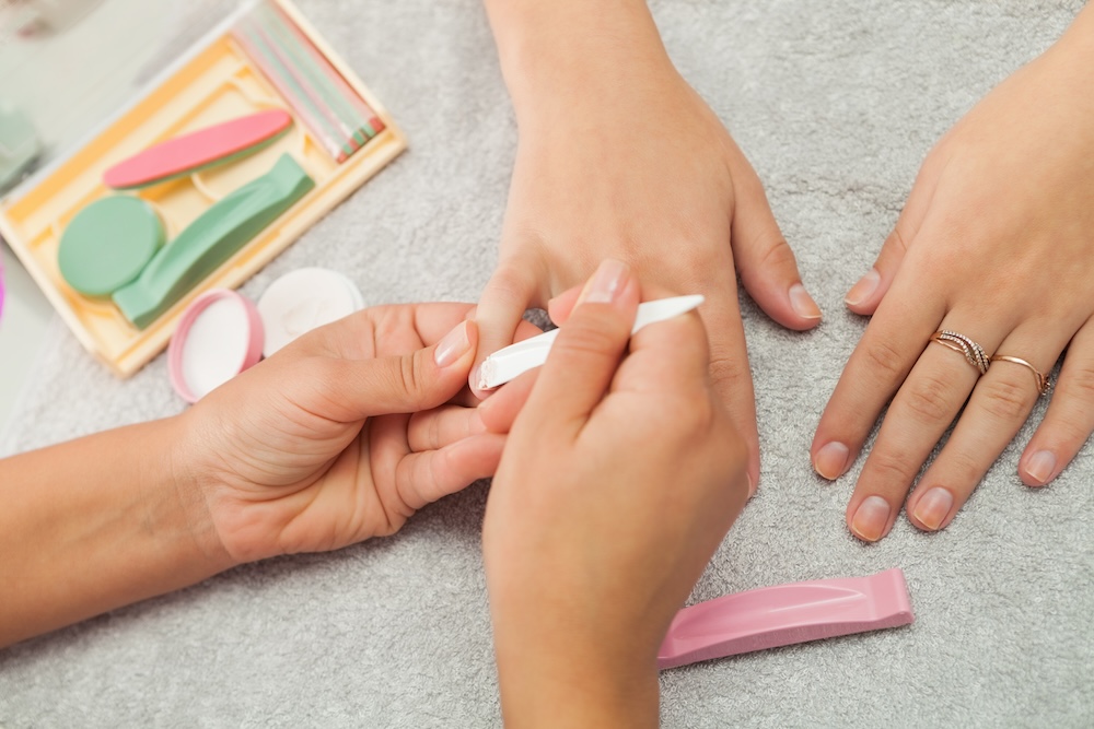 Close-up of a nail technician buffing the nails during a Japanese manicure treatment