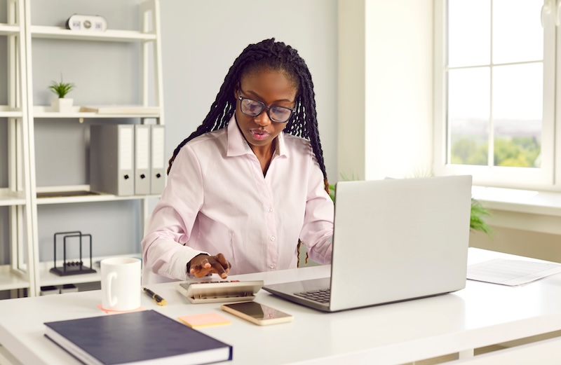 Beauty salon owner reviewing accounts and payroll on a computer, preparing for Autumn Budget 2025 changes