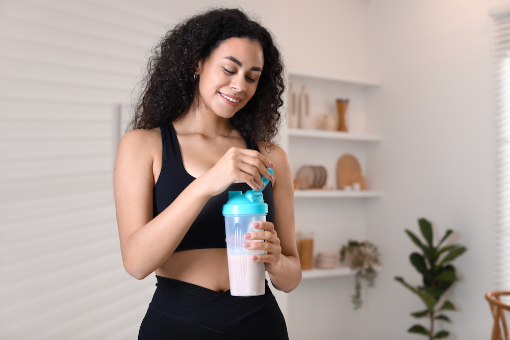 Woman it fitness clothes holding a drinks shaker
