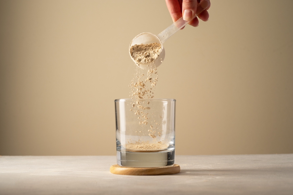 Powder supplement being scooped into a glass