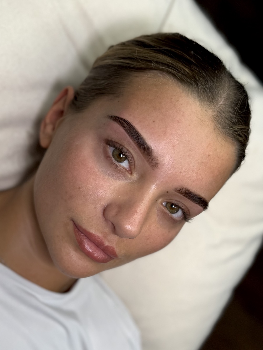 Woman with sculpted brows lying on treatment bed