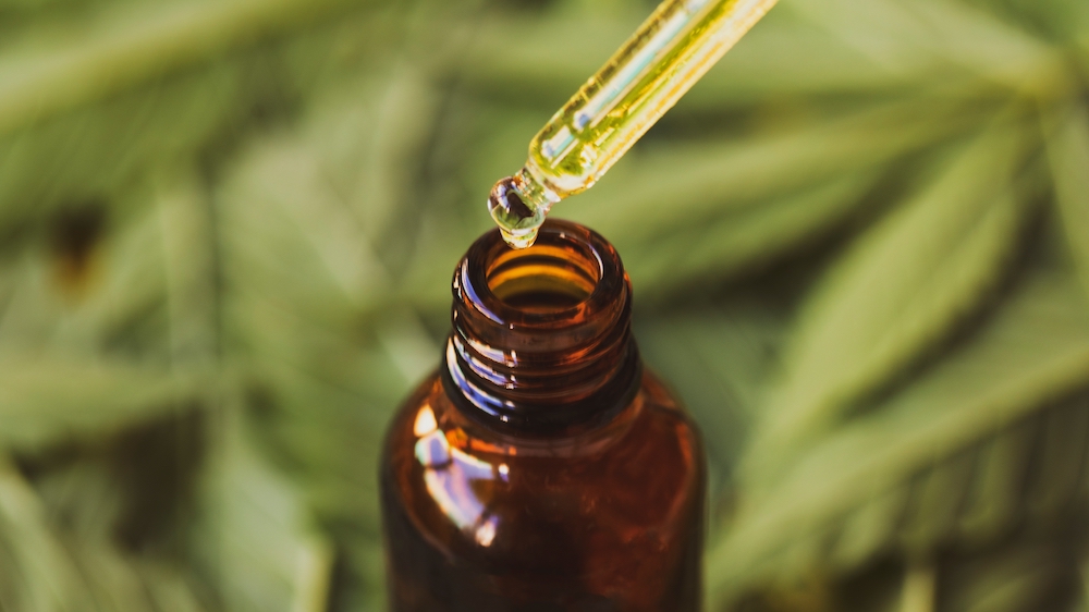 CBD oil in small glass bottle with dropper