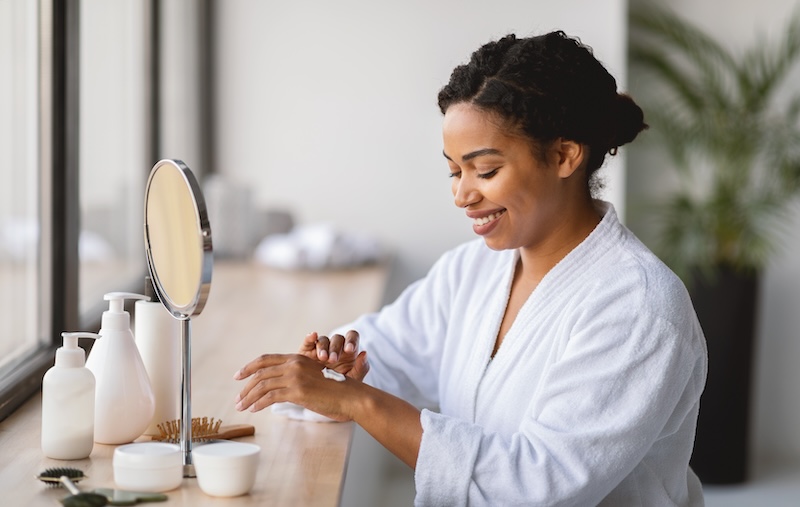 Client applying skincare products at home as part of a daily routine for stressed skin