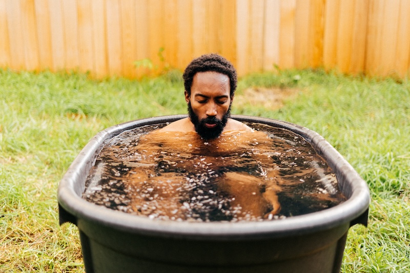 Man using a cold plunge pool as part of contrast therapy at a wellness spa