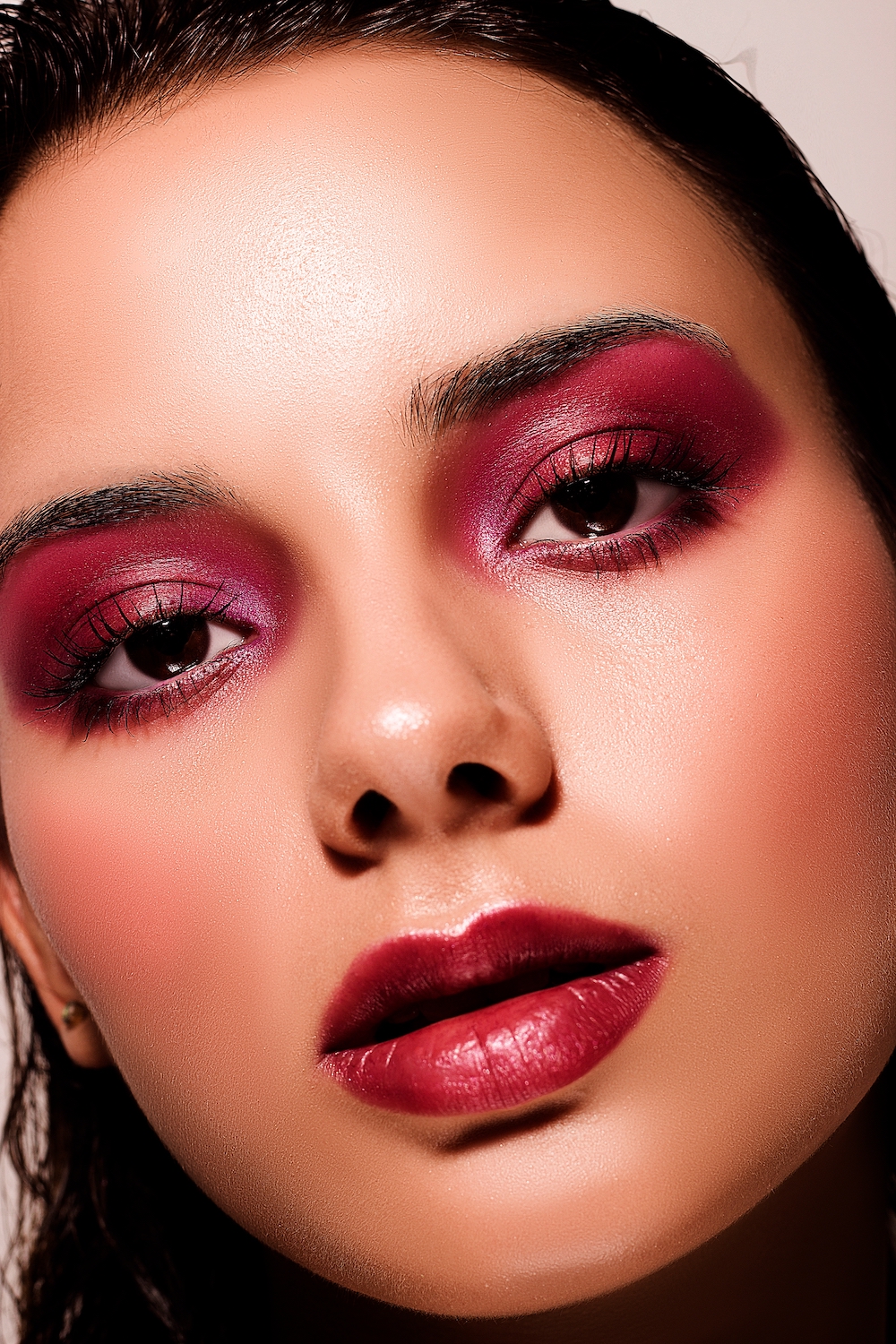 Close up of woman with deep pink eyeshadow and berry toned lipstick