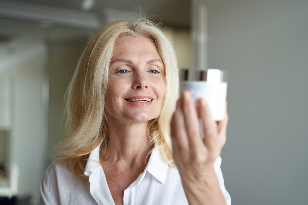 Woman reading the label of ingredients on skincare product