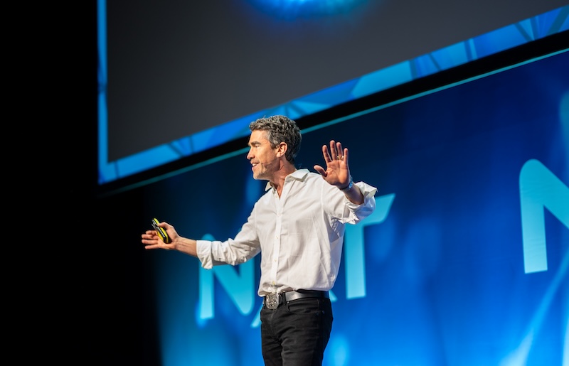 Jason Bevan presenting to an audience on stage