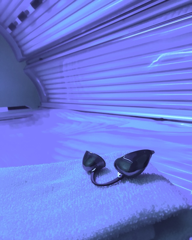 Close-up of a tanning bed with protective goggles, highlighting UV exposure risks