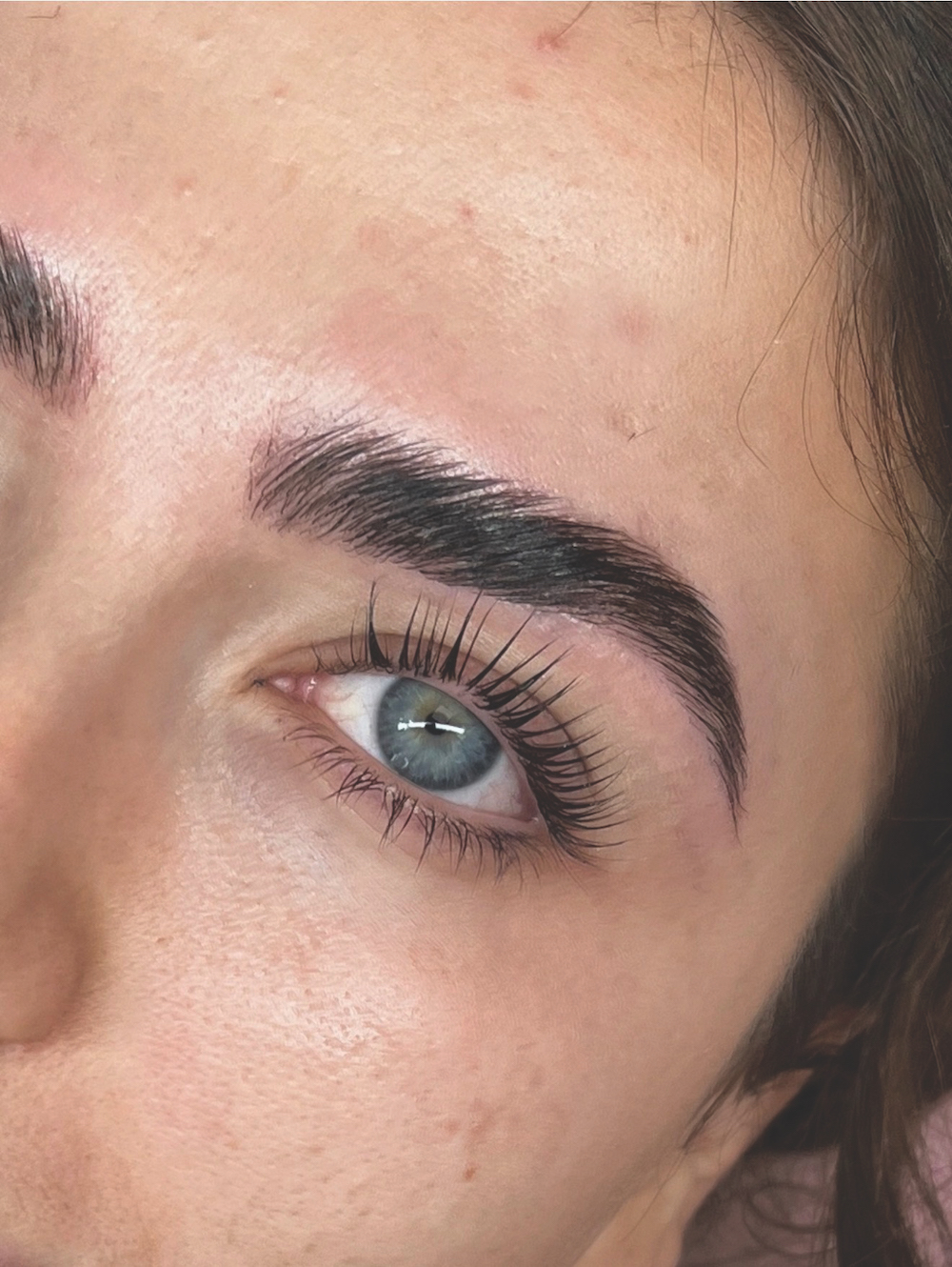Close up of woman with a Korean lash lift &ndash; long black curled lashes