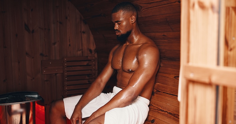 Man relaxing in a sauna as part of a contrast therapy session for stress relief, recovery, and improved circulation