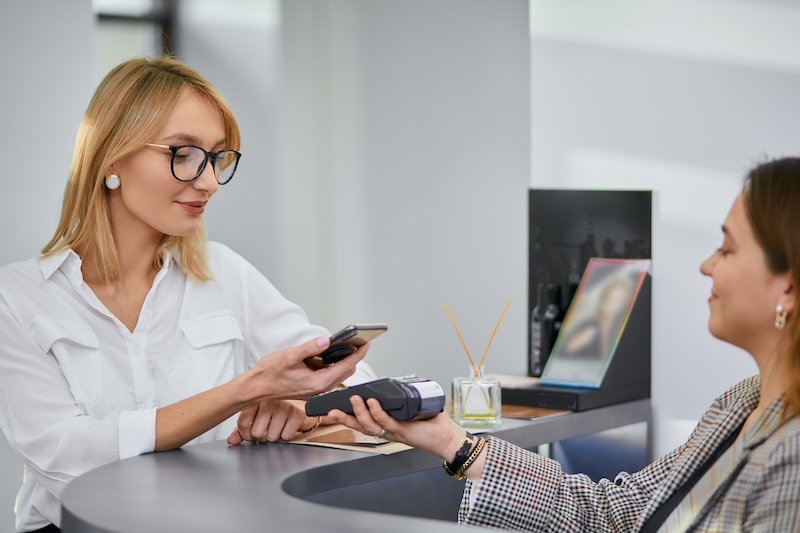 Client paying for a treatment at the reception desk in a beauty salon