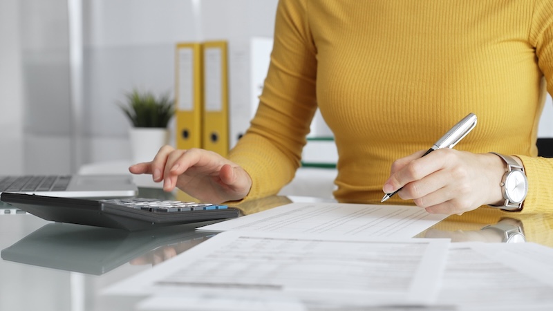 Small business owner reviewing tax documents and financial paperwork at a desk