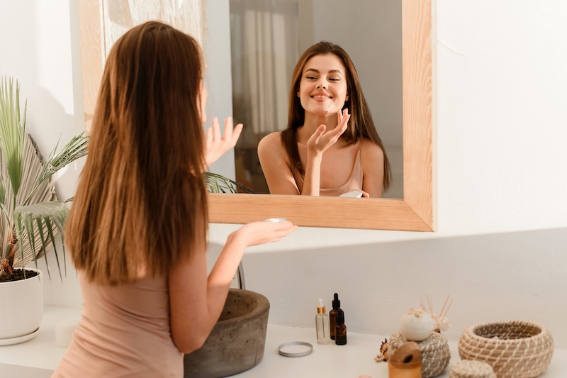 Woman applying skincare as part of a routine to treat multiple skin concerns
