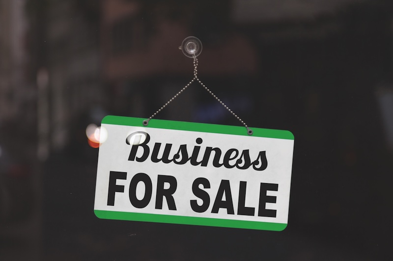 Business for sale sign displayed in a salon window, indicating the salon is on the market