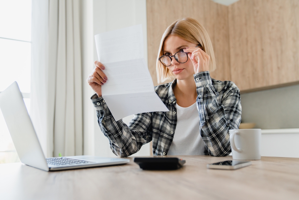 Woman sitting at home looking at bills and finances