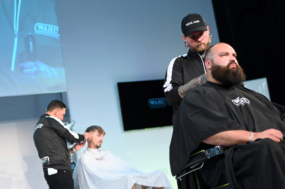 Wahl ambassador Rhys Whitehouse cutting a male model's hair on stage