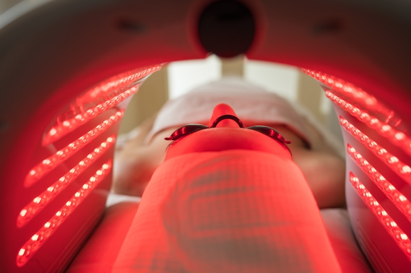 Young woman receiving LED light therapy treatment in a skin clinic as part of a preventative prejuvenation skincare routine