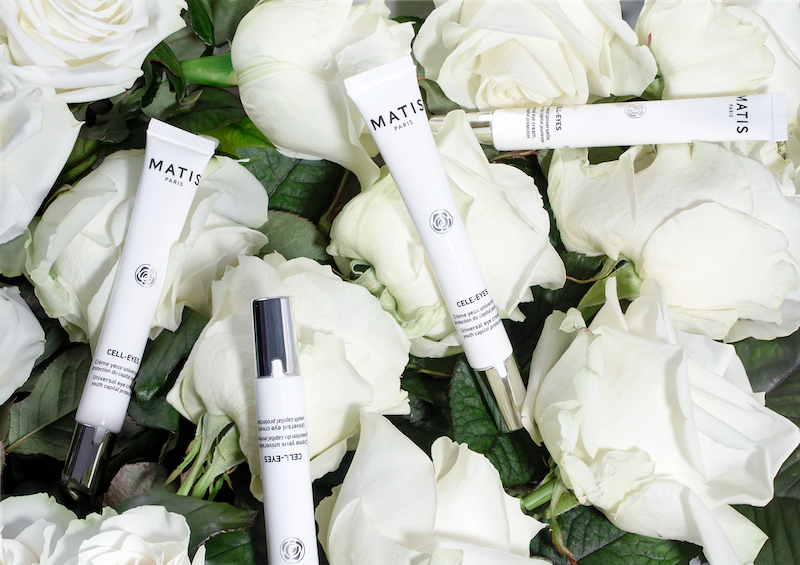 Cell-Eyes eye cream tubes displayed on white rose petals, highlighting white rose stem cell technology in professional skincare