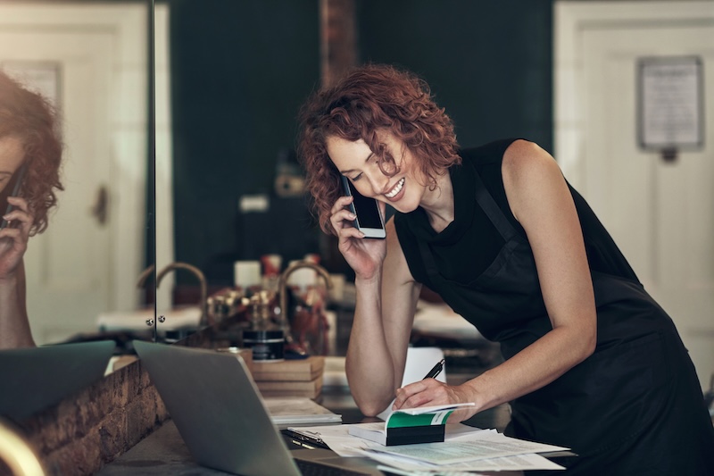 Salon owner booking a client appointment over the phone, managing salon scheduling to improve client retention and increase bookings