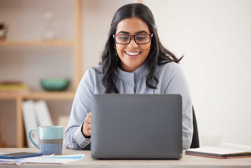 Salon owner reviewing business metrics and performance data on a laptop to track profitability, improve salon revenue and support business growth