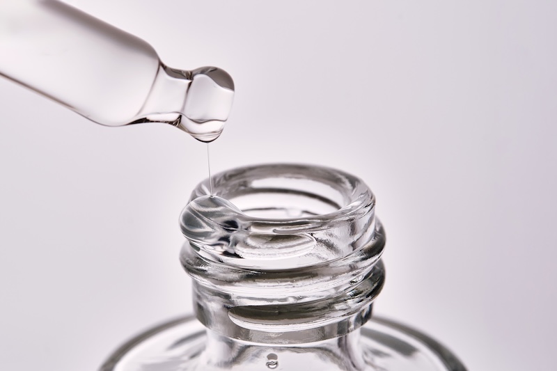 Close-up of a skincare serum bottle with pipette showing serum texture used in nanoneedling treatment