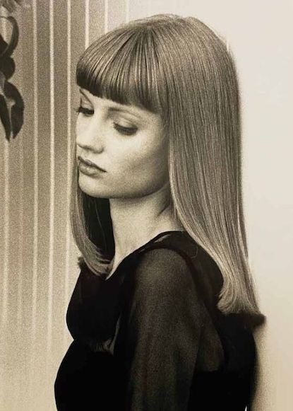 Black and white image of model with straight, mid-length hair and full fringe