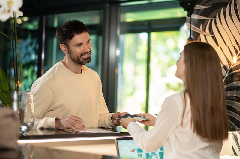 Client rebooking a future appointment at a salon reception desk, demonstrating customer retention and rebooking strategies.