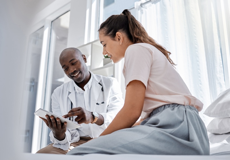 Patient discussing treatment options with a doctor during a consultation in a clinic setting.