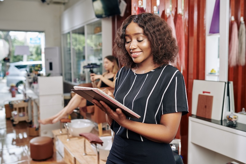 Beauty salon owner reviewing key 2026 cosmetics regulation deadlines on a tablet