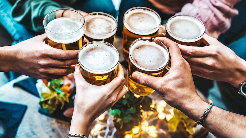 Group of people holding beers in a pub included in the new business rates cut
