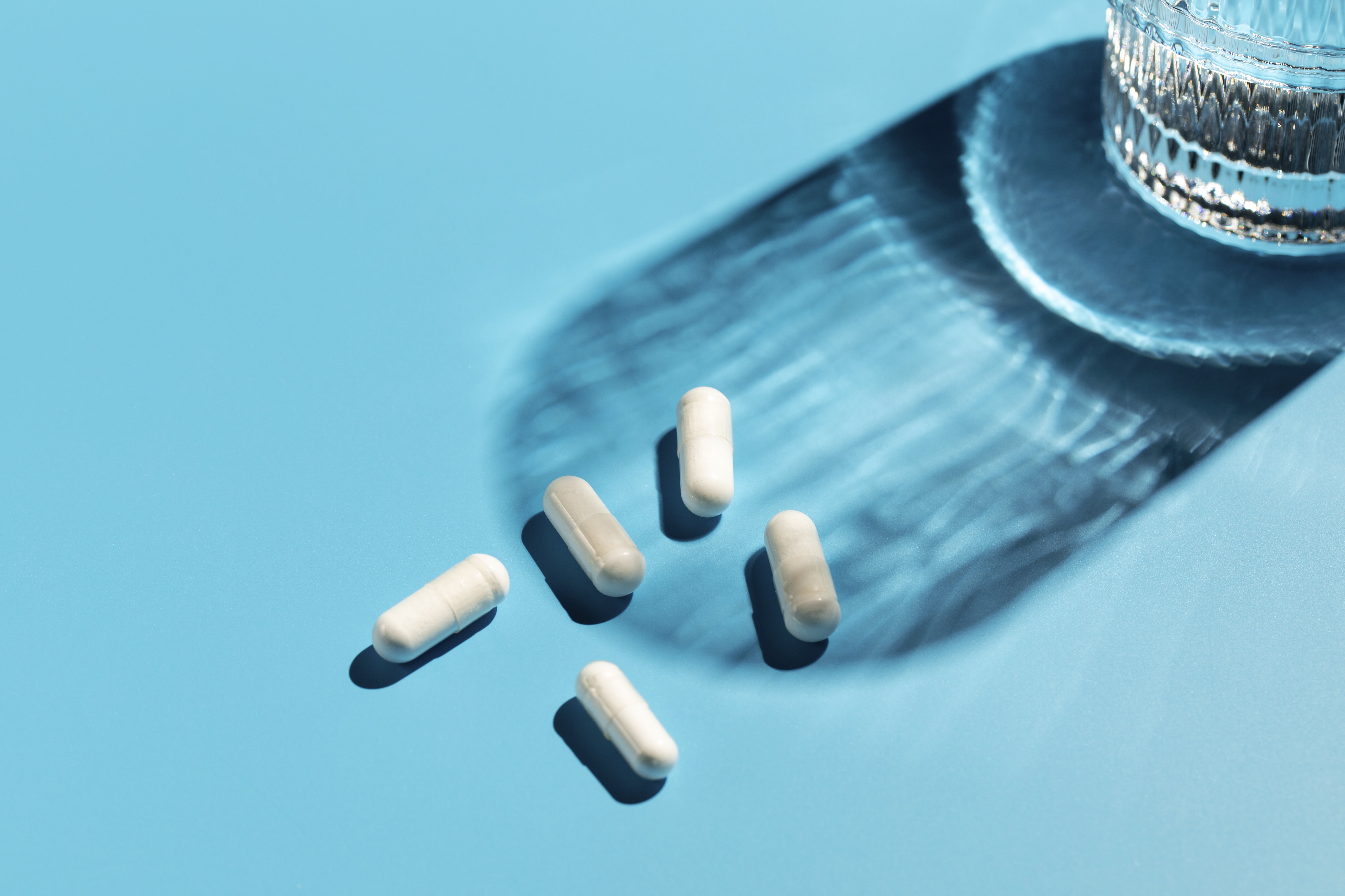 supplements on a table with a glass of water