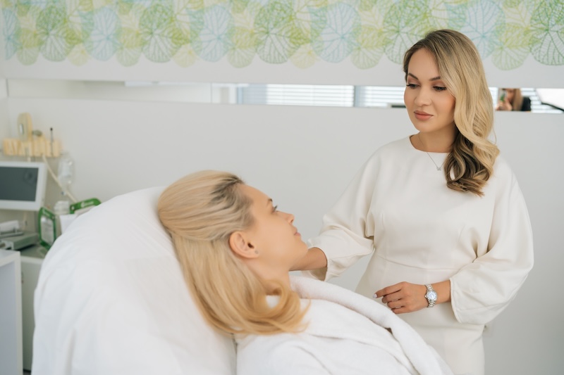 Beauty therapist consulting with a pregnant client before a spa treatment